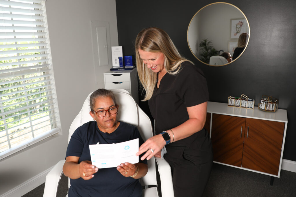 A woman is taught about chemical peel at mind and body medspa in versailles, kentucky